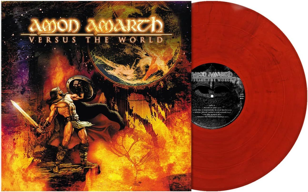 Amon Amarth Versus the World album artwork featuring a Norse warrior with sword and shield surrounded by flames, dramatic Viking metal cover art shown with red vinyl LP pressing, available from Utopia Records.